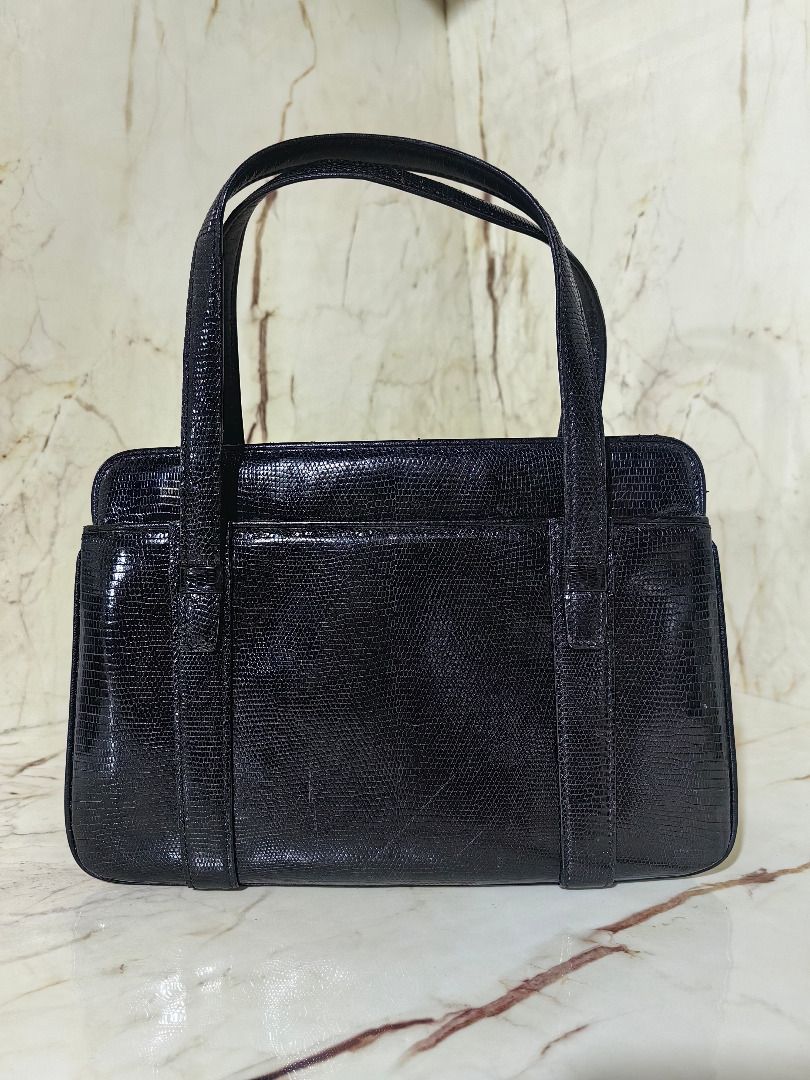 Genuine Lizard Skin Handbag (Category: Shoulder Bags) located in Tarlac. Submitted by jeremiah.curator.2026 (Listing ID 1468536853, Image 2). Description: - Color & Texture: Elegant Black Lizard Skin Leather - Hardware: Modern silver-tone accents on front straps - Closure: Secure kiss-lock top closure - Interior: Dark lining equipped with a convenient zippered pocket - Structure: Sturdy rectangular base maintains bag shape - Handles: Convenient d