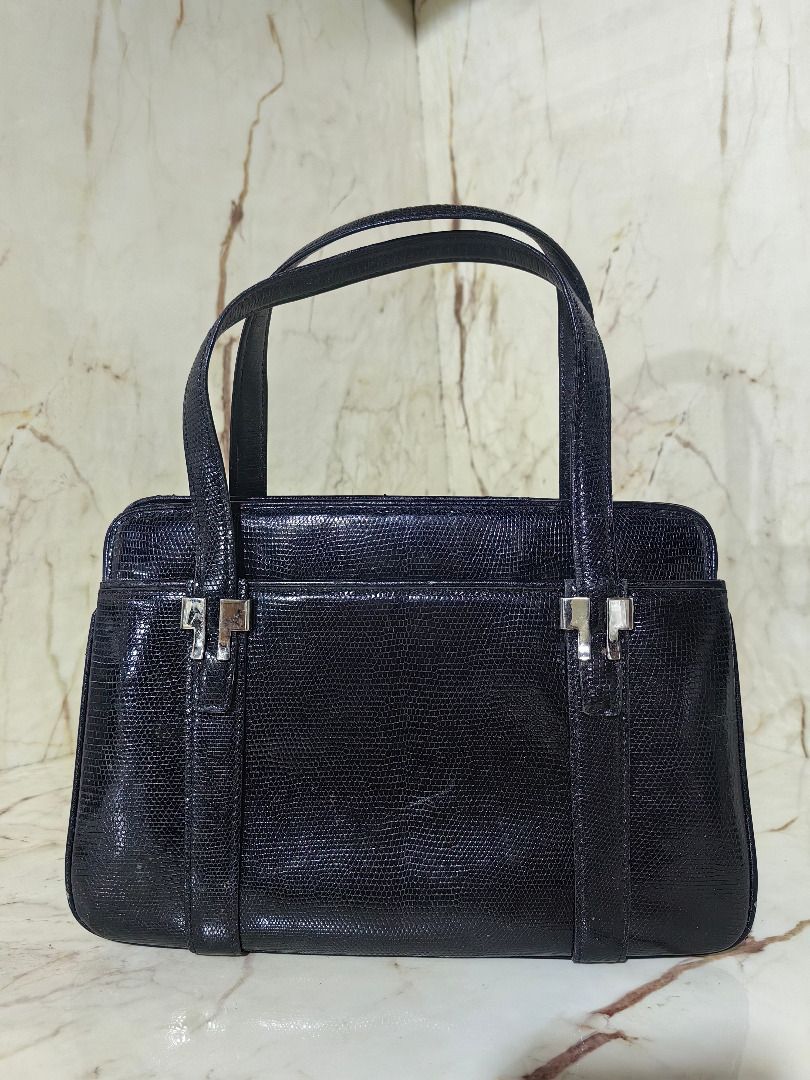 Genuine Lizard Skin Handbag (Category: Shoulder Bags) located in Tarlac. Submitted by jeremiah.curator.2026 (Listing ID 1468536853, Image 1). Description: - Color & Texture: Elegant Black Lizard Skin Leather - Hardware: Modern silver-tone accents on front straps - Closure: Secure kiss-lock top closure - Interior: Dark lining equipped with a convenient zippered pocket - Structure: Sturdy rectangular base maintains bag shape - Handles: Convenient d