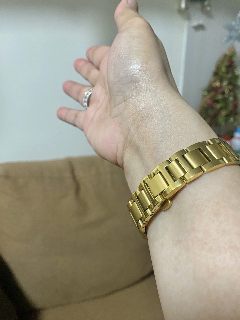 Gold Watch (Category: Women's Watches) located in Makati City. Submitted by dpjanssen (Listing ID 1468617410, Image 2). Description: - Color/Material: Gold-tone metal link bracelet with deployment clasp - Dial: Round dial featuring classic Roman numerals and elegant blue hands - Distinctive Feature: Signature crown guard with a blue cabochon - Condition: Excellent working condition, keeps time properly, - Inclusions: Ready to wear - very nice in 