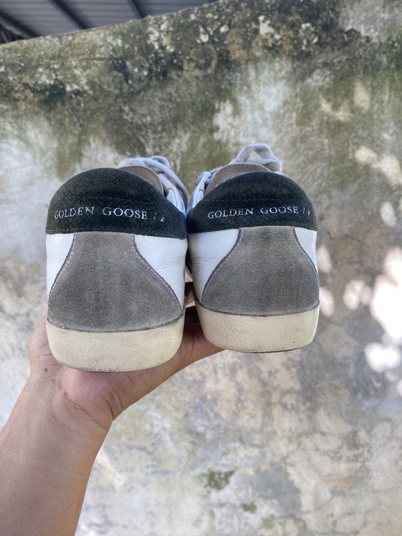 Golden Goose Superstar White Sneakers (Category: Sneakers) located in Iloilo. Submitted by resellmpg (Listing ID 1468558189, Image 2). Description: - Brand: Golden Goose - Color: White leather with grey suede star and dark green heel tab - Design: Signature distressed finish on midsole and upper - Details: Grey laces, classic low-top silhouette, white logo lettering on heel - Mode of Payment: BPI, GCash, or COD available - Shipping: Via LBC or sa