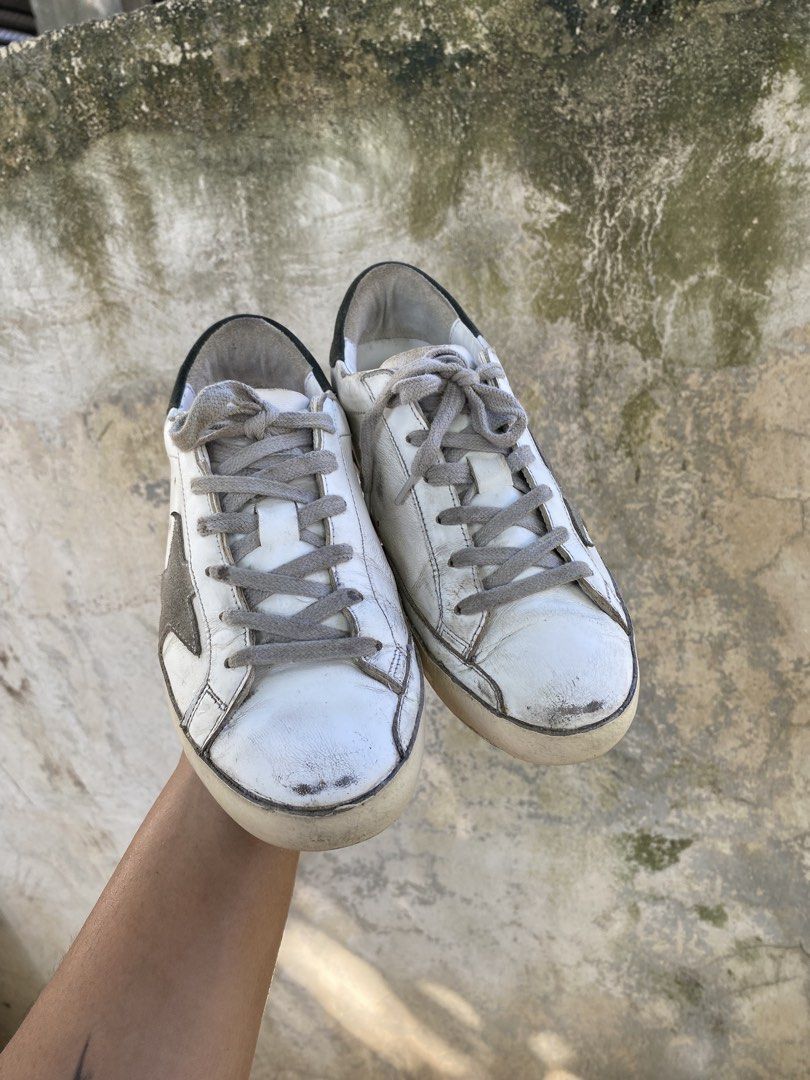 Golden Goose Superstar White Sneakers (Category: Sneakers) located in Iloilo. Submitted by resellmpg (Listing ID 1468558189, Image 3). Description: - Brand: Golden Goose - Color: White leather with grey suede star and dark green heel tab - Design: Signature distressed finish on midsole and upper - Details: Grey laces, classic low-top silhouette, white logo lettering on heel - Mode of Payment: BPI, GCash, or COD available - Shipping: Via LBC or sa