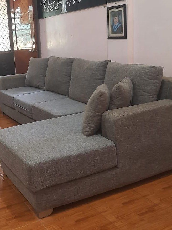 Gray L-shaped Sectional Sofa with Chaise (Category: Sofas) located in Pasay City. Submitted by daisuki.x0x0 (Listing ID 1468504064, Image 1). Description: - Color: Neutral gray fabric that easily matches any living room decor - Layout: Sectional sofa with an extended chaise lounge on the right side - Includes: Two (2) matching throw pillows - Design: Stylish solid wooden legs visible underneath - Condition: Clean surface, gently used in a home se