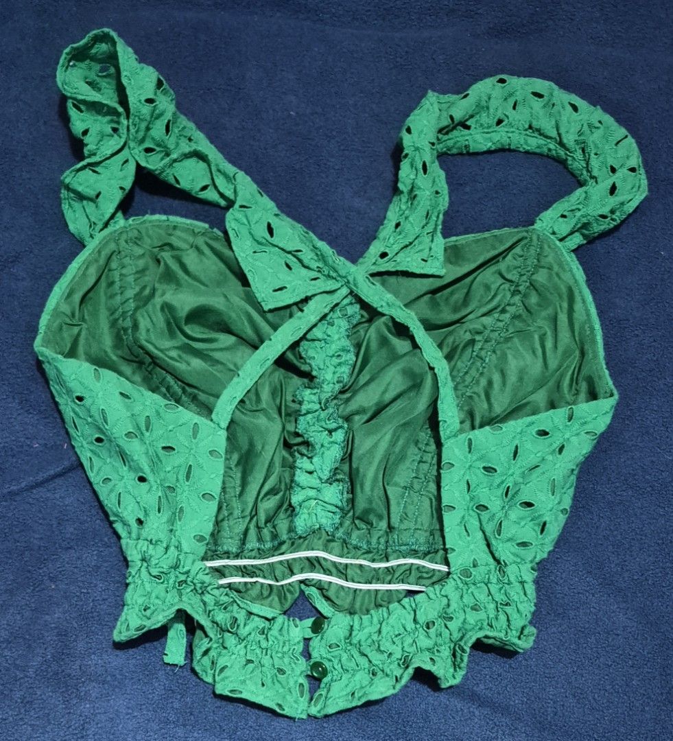 Green Eyelet Crop Top Ruffle Straps Smocked Back (Category: Sleeveless) located in Imus. Submitted by shopestepanimey (Listing ID 1468552622, Image 2). Description: - Color: Vibrant green - Material: Airy cotton with allover cut-out embroidery - Fit: Stretchy smocked hem for a comfortable fit - Details: Ruffled crossover straps in the back, button closure near the bottom edge - Lining: Fully lined interior - Style: Perfect for warm weather or lay