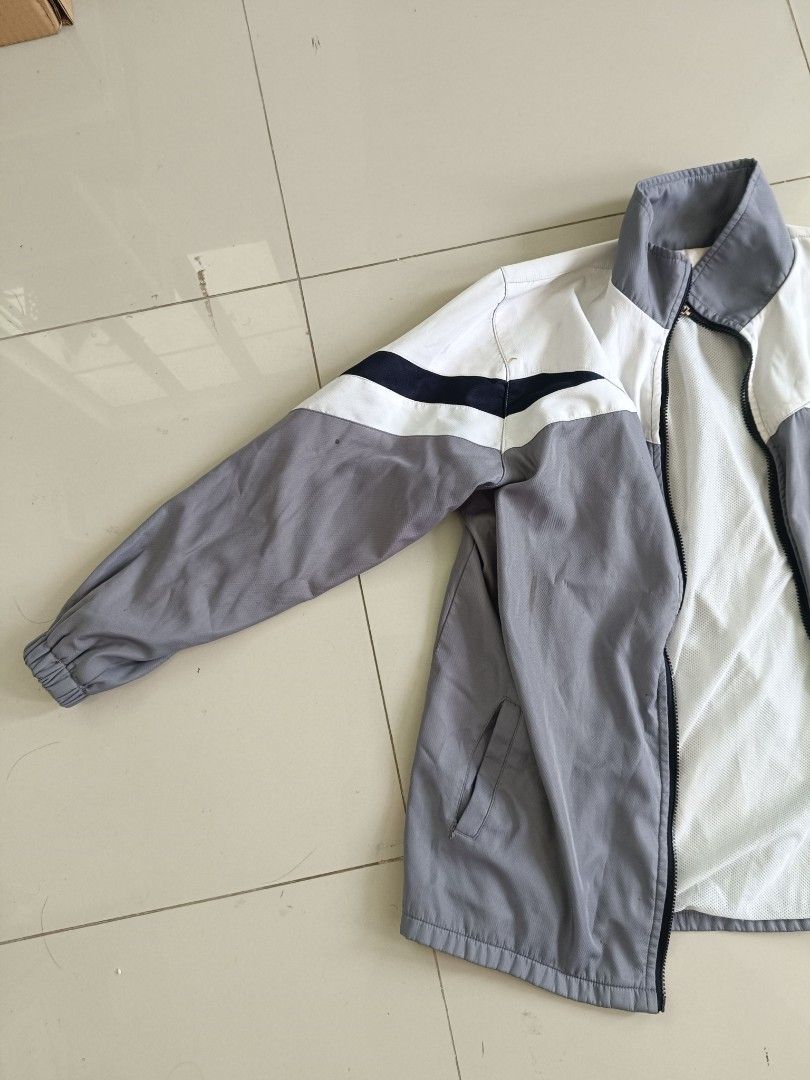Grey & White Zip-Up Windbreaker Jacket (Category: Coats, Jackets and Outerwear) located in Valenzuela. Submitted by justgorjas (Listing ID 1468502186, Image 2). Description: Women's / Unisex Outerwear (Zip-up Jacket / Windbreaker) Feng Ming High School - School Uniform / Varsity Windbreaker) Taiwan (Imported) Estimated Medium to Large (Fits comfortable M–L, relaxed fit) Color: Light Grey / White / Navy Blue Material: Lightweight Polyester Outer /