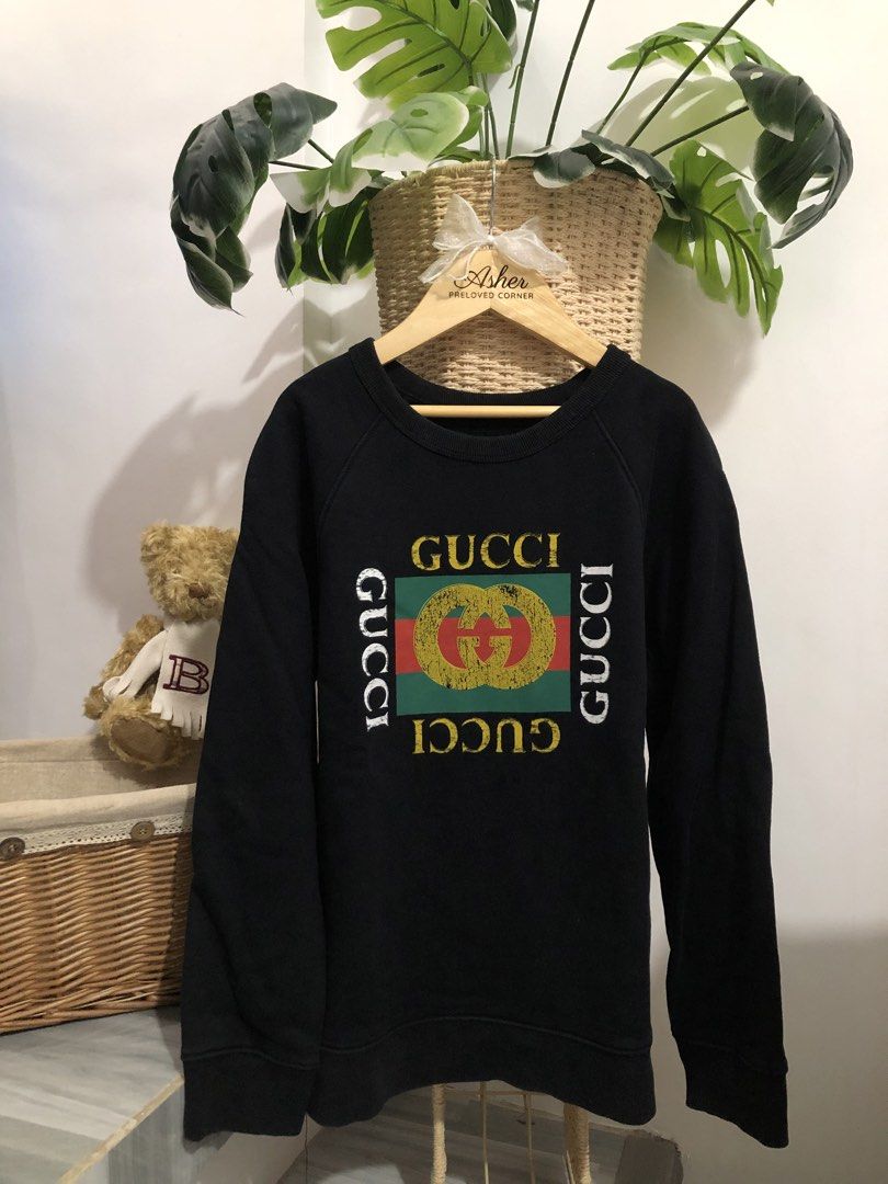 Gucci Black Logo Sweatshirt (Category: Babies & Kids Fashion) located in Dasmarinas. Submitted by xrenren (Listing ID 1468710541, Image 1). Description: - Brand: Gucci - Color: Black - Style: Vintage-style distressed graphic print with interlocking G logo on chest - Design: Classic crewneck, long sleeves, standard fit - Details: Ribbed collar, cuffs, and hem - Material: Soft and comfortable cotton blend - Condition: Excellent / High quality - Mod