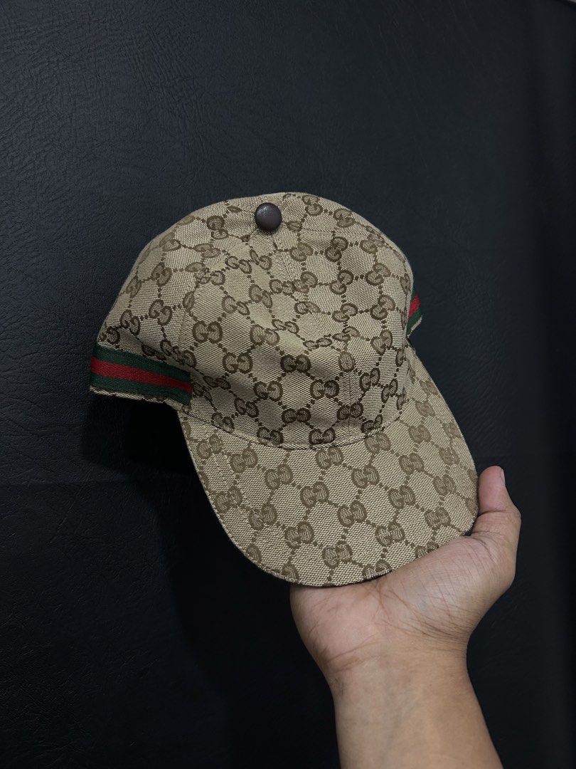 Gucci GG Canvas Baseball Cap Size L (Category: Caps & Hats) located in Manila. Submitted by bodegabodega (Listing ID 1468558521, Image 1). Description: Gucci baseball cap in beige and brown GG canvas pattern. Features the classic green and red web stripe on the sides. Adjustable brown leather strap at the back with debossed Gucci logo and serial number 200035 601491. Size L, 59 cm. Brown interior lining with Gucci fabric tag and care labels intac