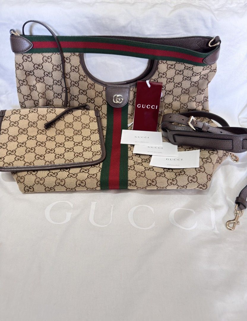 Gucci Giglio large Tote Bag Original (Category: Tote Bags) located in Manila. Submitted by vser88 (Listing ID 1468555344, Image 1). Description: - Iconic classic GG monogram canvas with green and red web stripe - Premium brown leather trim and comfortable top handles - Spacious green fabric interior with gold-tone hardware and interlocking G detail - Includes matching zippered pouch and extra leather shoulder strap - Comes complete with original 