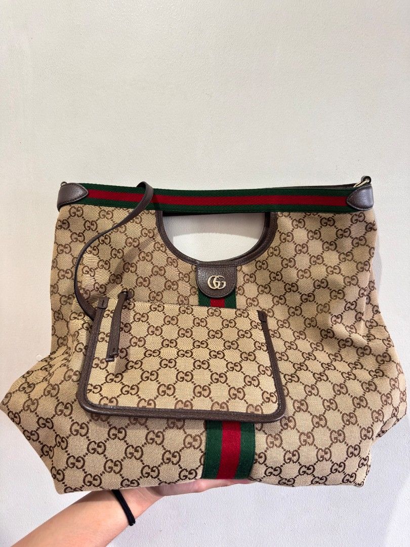 Gucci Giglio large Tote Bag Original (Category: Tote Bags) located in Manila. Submitted by vser88 (Listing ID 1468555344, Image 2). Description: - Iconic classic GG monogram canvas with green and red web stripe - Premium brown leather trim and comfortable top handles - Spacious green fabric interior with gold-tone hardware and interlocking G detail - Includes matching zippered pouch and extra leather shoulder strap - Comes complete with original 