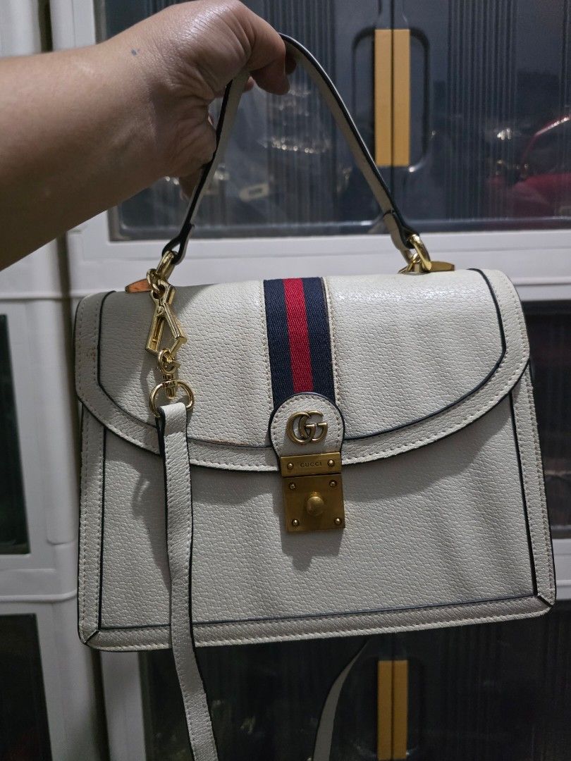 Gucci White Leather Handbag with Web Stripe (Category: Cross-body Bags) located in Lemery. Submitted by venus23 (Listing ID 1468665322, Image 1). Description: - Brand: Gucci - Material: Premium white leather with dark piping edges - Design: Iconic blue and red web stripe with gold-tone hardware and interlocking GG clasp - Features: Structured multi-compartment interior, top handle, and matching adjustable shoulder strap.