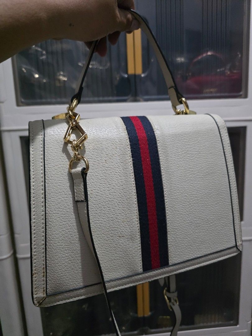 Gucci White Leather Handbag with Web Stripe (Category: Cross-body Bags) located in Lemery. Submitted by venus23 (Listing ID 1468665322, Image 2). Description: - Brand: Gucci - Material: Premium white leather with dark piping edges - Design: Iconic blue and red web stripe with gold-tone hardware and interlocking GG clasp - Features: Structured multi-compartment interior, top handle, and matching adjustable shoulder strap.
