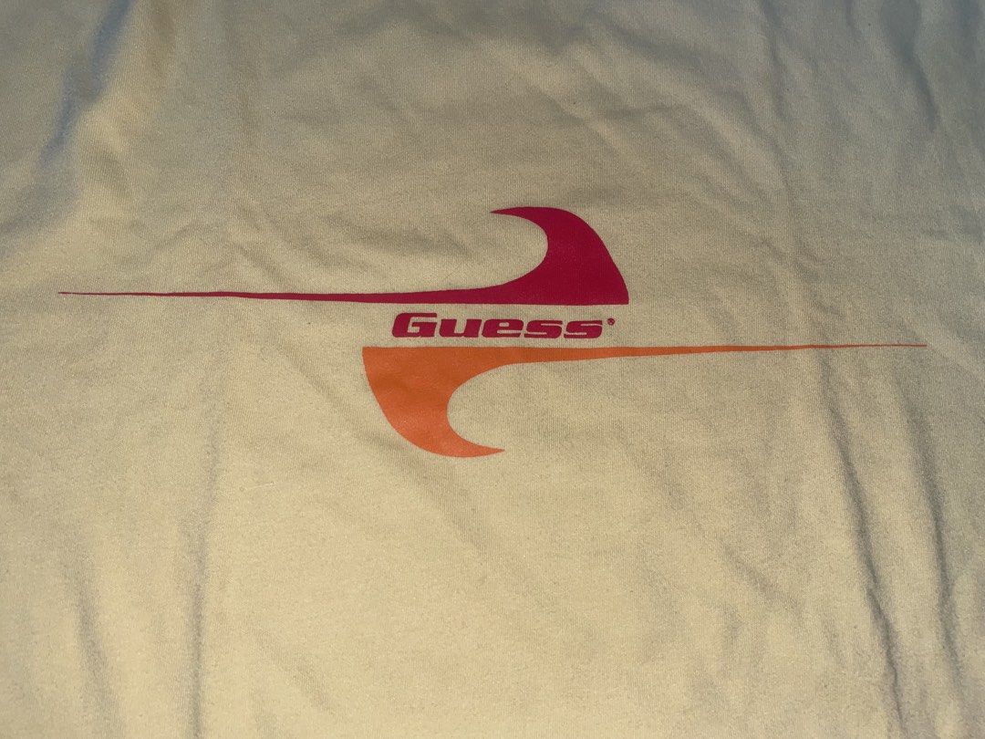Guess Yellow Graphic Tee Size L (Category: Tshirts & Polo Shirts ) located in Manila. Submitted by joshua_guimeroy. (Listing ID 1468524417, Image 2). Description: - Brand: Guess - Size: Large - Condition: Brand new with tags attached - Material: 100% cotton - Fit: Relaxed fit with standard crew neck and short sleeves - Design: Retro front graphic featuring pink and orange waves with the Guess logo - Color: Yellow.