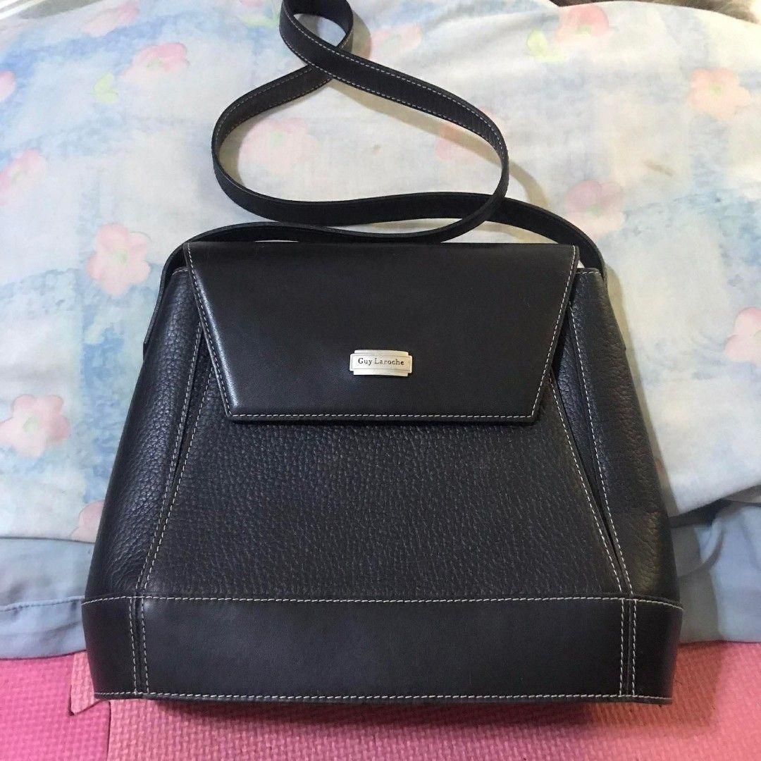 Guy Laroche black leather shoulder bag (Category: Shoulder Bags) located in Manila. Submitted by thehotness2.0 (Listing ID 1468581895, Image 1). Description: - Brand: Guy Laroche - Material: Genuine smooth and pebbled leather - Color: Classic black with stylish white contrast stitching - Design: Structured trapezoid shape with front flap closure - Hardware: Elegant silver metal brand plaque - Strap: Convenient and adjustable shoulder strap - Cond