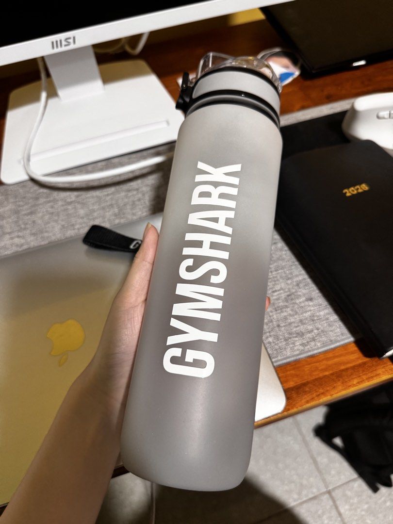 Gymshark Grey Water Bottle With Strap (Category: Water Bottles & Tumblers) located in Manila. Submitted by ivoryscloset (Listing ID 1468518477, Image 1). Description: - Authentic Gymshark frosted grey water bottle - Features a large white vertical logo on the side - Clear flip-top lid equipped with a secure latch - Convenient black carrying strap for easy transport - Brand new in original white box and plastic wrapping - Ideal for the gym, runnin