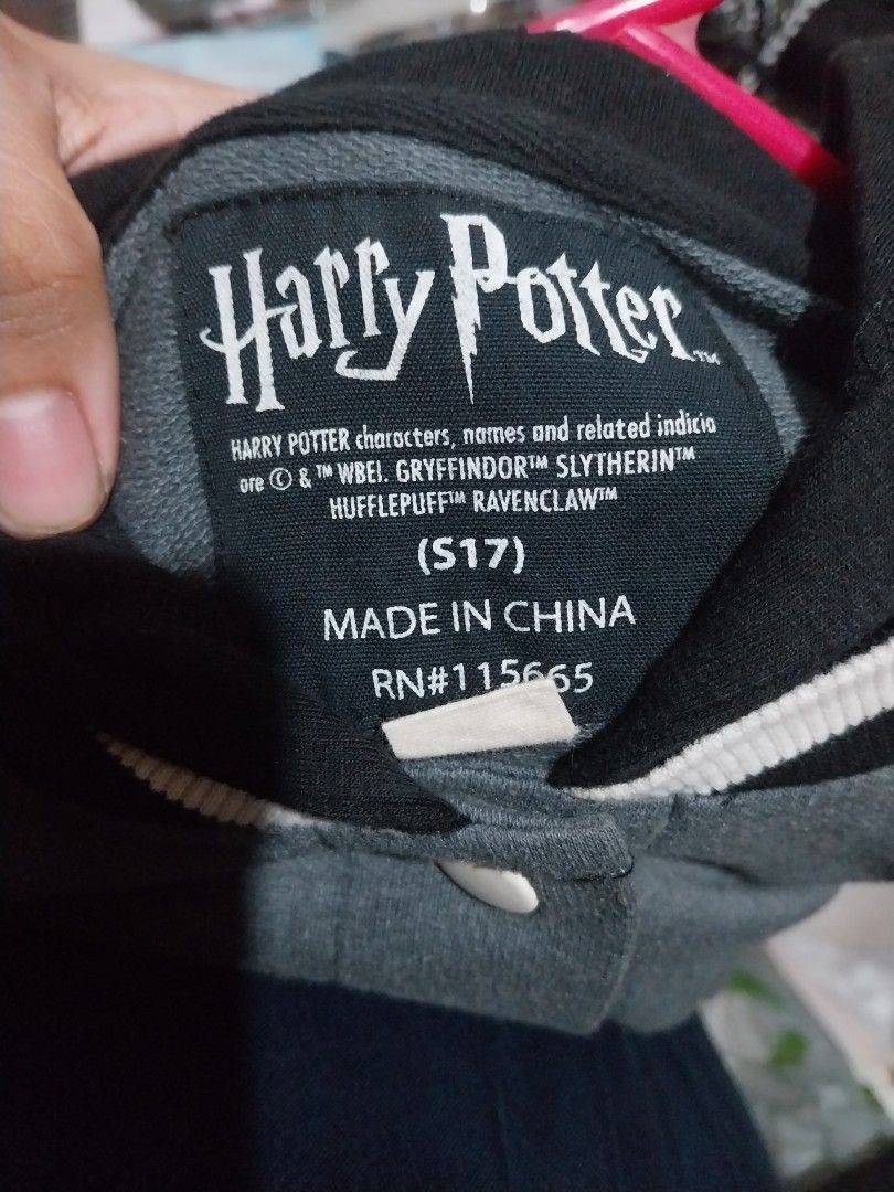 Harry Potter Gryffindor Varsity Jacket official merch (Category: Coats, Jackets and Outerwear) located in Manila. Submitted by j.dlh (Listing ID 1468662836, Image 3). Description: - Official Harry Potter Gryffindor varsity jacket - Color: Grey and black with an attached black hood - Embroidered Gryffindor crest on the chest - Vertical 'POTTER' lettering on the back in yellow and maroon - Snap button front closure - Striped ribbed collar, cuffs, a