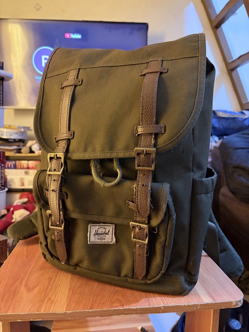 Herschel Green Backpack with Brown Straps (Category: Backpacks) located in Caloocan City. Submitted by gentletiger_34152c (Listing ID 1468563534, Image 1). Description: Green Herschel Supply Co. backpack with brown faux leather straps and metal buckles. Front pocket has the classic woven brand label. Drawstring main compartment closure beneath the top flap. Striped fabric lining inside with a "Put Yourself Out There" patch. Padded shoulder straps