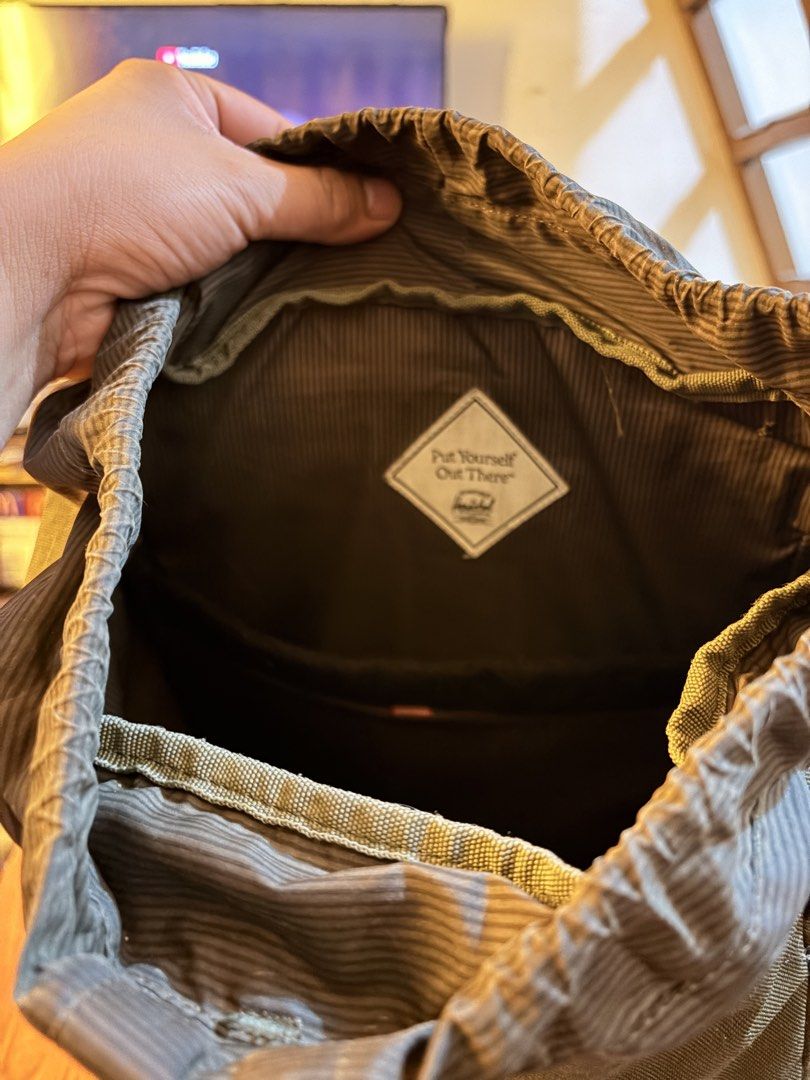 Herschel Green Backpack with Brown Straps (Category: Backpacks) located in Caloocan City. Submitted by gentletiger_34152c (Listing ID 1468563534, Image 3). Description: Green Herschel Supply Co. backpack with brown faux leather straps and metal buckles. Front pocket has the classic woven brand label. Drawstring main compartment closure beneath the top flap. Striped fabric lining inside with a "Put Yourself Out There" patch. Padded shoulder straps