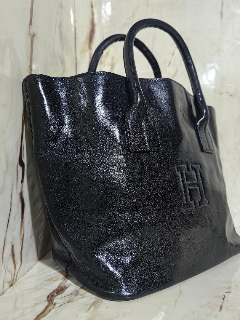 HIROFU Black Leather Tote Bag (Category: Tote Bags) located in Tarlac. Submitted by jeremiah.curator.2026 (Listing ID 1468502667, Image 3). Description: - Sleek black leather tote bag with dual structured top handles - Features a chic embossed H logo on the front panel - Roomy open-top main compartment for easy access - Includes a convenient interior zippered side pocket - Luxurious unlined suede interior finish - Clean and durable stitching deta