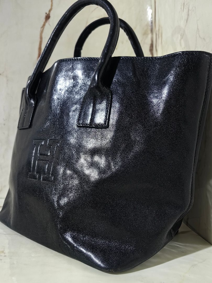 HIROFU Black Leather Tote Bag (Category: Tote Bags) located in Tarlac. Submitted by jeremiah.curator.2026 (Listing ID 1468502667, Image 2). Description: - Sleek black leather tote bag with dual structured top handles - Features a chic embossed H logo on the front panel - Roomy open-top main compartment for easy access - Includes a convenient interior zippered side pocket - Luxurious unlined suede interior finish - Clean and durable stitching deta