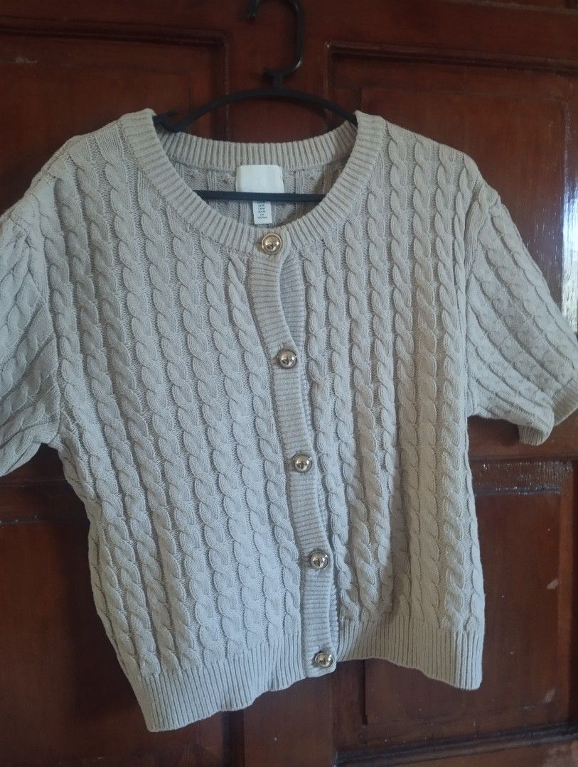 H&M Cable Knit Short Sleeve Cardigan (Category: Coats, Jackets and Outerwear) located in Manila. Submitted by ljaneee (Listing ID 1468553611, Image 2). Description: - Brand/Style: H&M short-sleeve cable knit cardigan - Color: Neutral beige - Size: Medium (M) - Details: Crew neck, thick textured knit, shiny gold-tone round buttons, ribbed collar, cuffs, and hem - Condition: Clean fabric, no pulls or loose threads - Styling: Easy to pair with high-