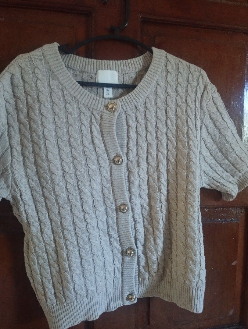 H&M Cable Knit Short Sleeve Cardigan (Category: Coats, Jackets and Outerwear) located in Manila. Submitted by ljaneee (Listing ID 1468553611, Image 1). Description: - Brand/Style: H&M short-sleeve cable knit cardigan - Color: Neutral beige - Size: Medium (M) - Details: Crew neck, thick textured knit, shiny gold-tone round buttons, ribbed collar, cuffs, and hem - Condition: Clean fabric, no pulls or loose threads - Styling: Easy to pair with high-