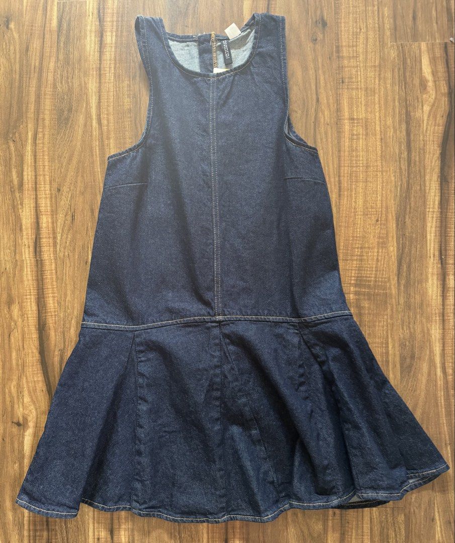 H&M Denim Dress (Category: Dresses) located in Silang. Submitted by xoxovintage98 (Listing ID 1468556497, Image 1). Description: - Brand: H&M Divided - Size: M - Condition: Brand new with original tags attached (never worn) - Material: Made with 20% recycled cotton - Style: Sleeveless, dark wash denim dress with a back zipper closure and trendy dropped waist flare skirt - Versatility: Perfect for casual days or layering over your favorite t-shirt