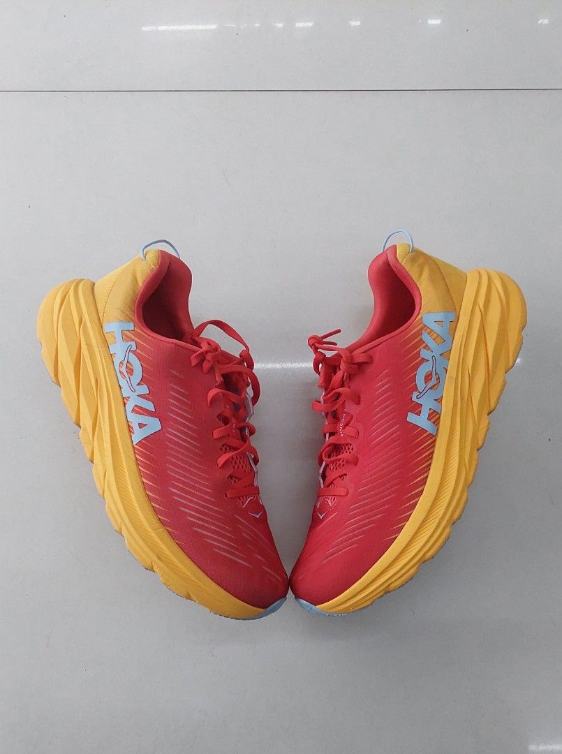 Hoka One One Rincon 3 Running Shoes (Category: Sneakers) located in Manila. Submitted by silentbear-c433 (Listing ID 1468540065, Image 2). Description: - Brand: Hoka One One Rincon 3 - Color: Bright Red and Yellow with Blue branding - Size: US 9.5 / UK 8 / EU 42 2/3 / JPN 27 - Features: Lightweight design, signature thick cushioned midsole - Condition: Clean uppers and soles, minimal wear shown in pictures.