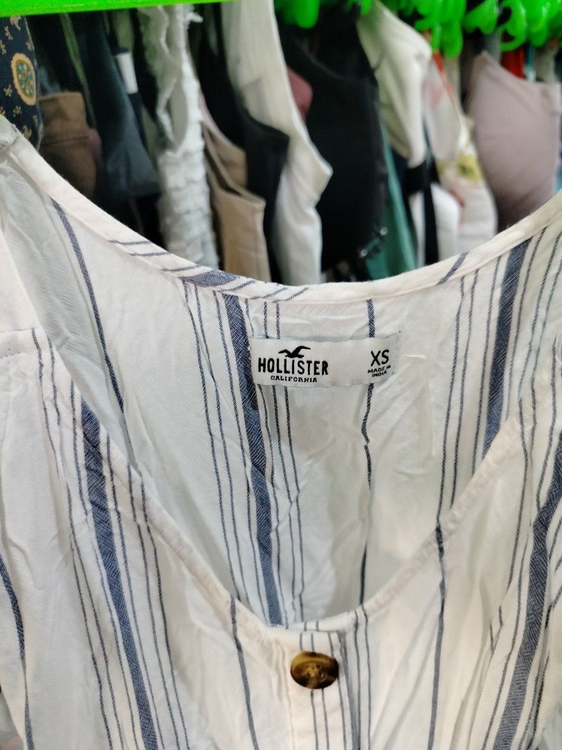 Hollister Striped Button-Front Cami Top Size XS (Category: Sleeveless) located in Manila. Submitted by virgiliosa38485 (Listing ID 1468520399, Image 2). Description: - Brand: Hollister California - Size: XS (Made in India) - Design: White with blue vertical stripes - Details: Button-down front with tortoiseshell buttons, scoop neckline, thin straps - Material: Lightweight fabric - Condition: Excellent / Pre-loved - Style: Easy to style for warm w