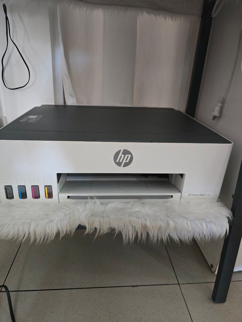 HP Smart Tank 210 All-in-One Printer (Category: Printers, Scanners & Copiers) located in Quezon City. Submitted by bon00 (Listing ID 1468562763, Image 1). Description: - Model: HP Smart Tank 210 (White and Dark Grey) - Ink System: Continuous ink tank with front-visible CMYK slots - Design: Compact footprint with paper tray supporting up to 8.5x11 inch paper - Control Panel: Easy-to-use digital display on top - Ideal For: Home offices and school w