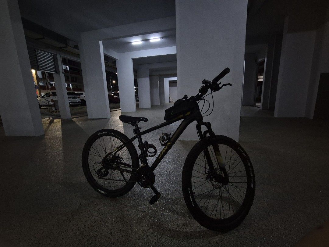 Java Mountain Bike (Category: Bicycles) located in Singapore. Submitted by ohzeening (Listing ID 1468582525, Image 1). Description: - Brand/Model: Black Java Mountain Bike - Condition: Ready to ride - Key Features: Front suspension fork, reliable disc brakes, and grippy knobby tires - Upgrades/Accessories Included: Frame bag on top tube, cable lock on seat tube, and flat pedals.