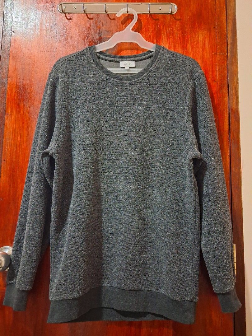 Jaxon Dark Grey Textured Sweatshirt (Category: Coats, Jackets and Outerwear) located in Manila. Submitted by jiejieph (Listing ID 1468707672, Image 1). Description: - Color: Dark grey - Style: Long-sleeve crew neck sweatshirt - Material/Texture: Unique textured fabric with ribbed cuffs and hem to hold its shape - Detail: Small white text graphic on the upper back - Fit: Comfortable and great for casual days or cooler weather.