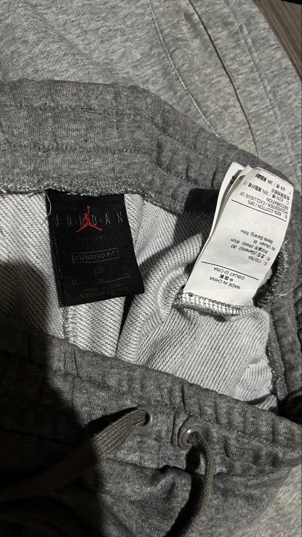 Jordan & Nike Grey Sweatpants Bundle Size M (Category: Joggers) located in Caloocan City. Submitted by lucky_jhonel (Listing ID 1468657776, Image 2). Description: - Bundle of 2 grey sweatpants (Size Medium) - Material: Cotton and polyester blend - Pair 1: Features large Jordan branding down the leg with Jumpman logo - Pair 2: Features a small Nike swoosh logo and standard issue tag near the pocket - Both feature adjustable drawstrings at the wais