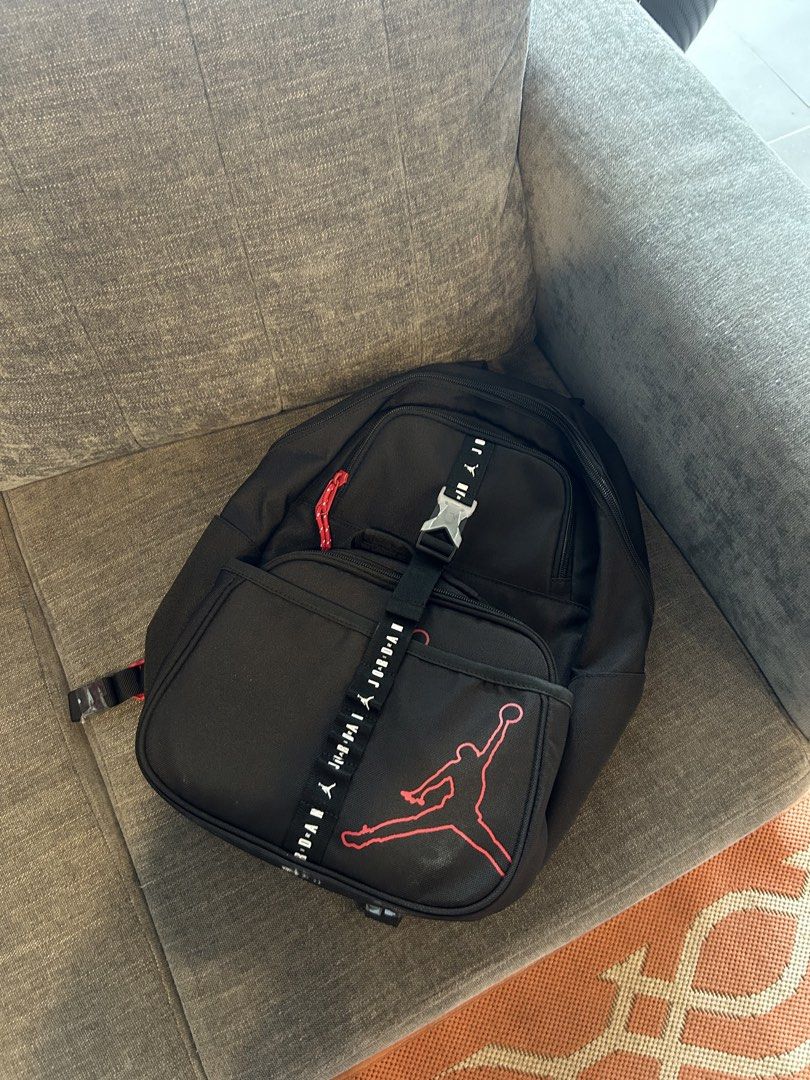 Jordan Black and Red Backpack with Lunch Bag Set (Category: Babies & Kids Fashion) located in San Fernando. Submitted by aljames1623 (Listing ID 1468576397, Image 1). Description: - Authentic Jordan backpack and matching lunch bag bundle - Sleek black design with iconic red Jumpman graphics and branded straps - Backpack features a secure front buckle closure - Lunch box showcases bold Jordan lettering across the front - Ideal set for school, spor