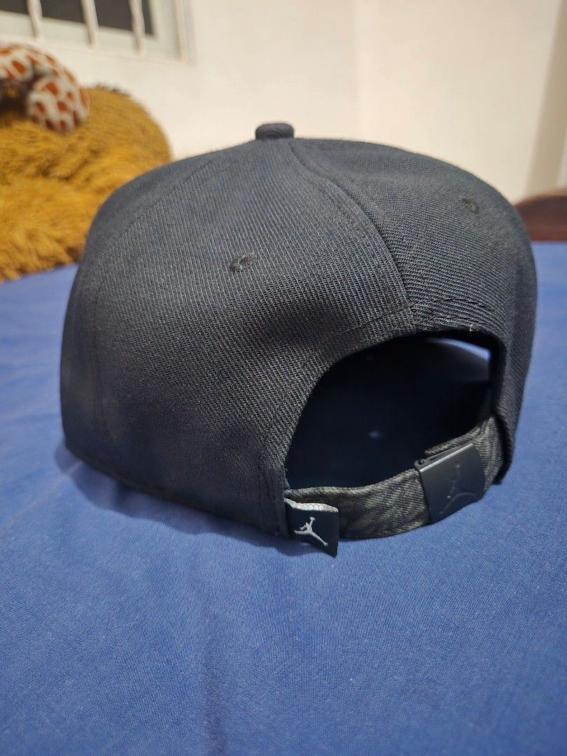 Jordan Jumpman Strapback Cap Black Bronze Elephant Bill (Category: Caps & Hats) located in Pasig City. Submitted by lordcajayon (Listing ID 1468679629, Image 2). Description: - Brand: Jordan - Color: Black with dark grey elephant print brim - Logo: Textured gold Jumpman logo on the front - Authenticity: Includes official hologram sticker on the brim - Fit: Adjustable strap at the back with a metal clasp and small Jumpman tag - Details: Inside tap