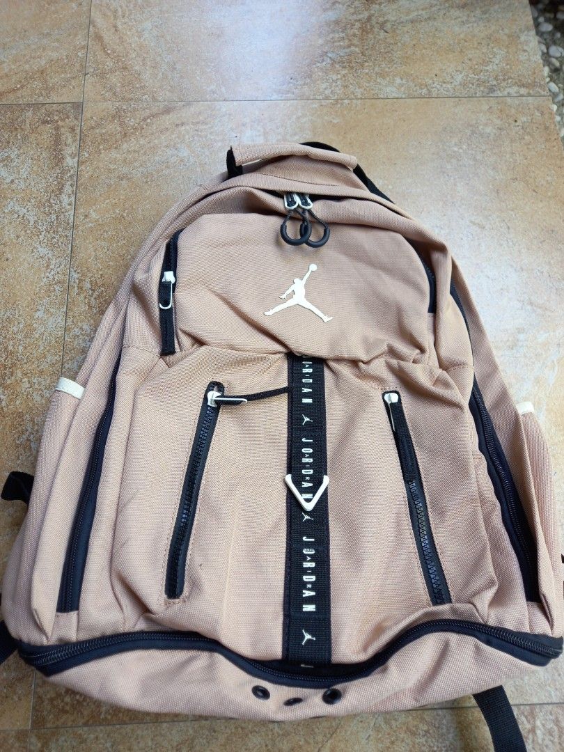 Jordan Jumpman Tan Backpack (Category: Backpacks) located in Davao. Submitted by kirk214red-50020 (Listing ID 1468530637, Image 1). Description: - Color: Tan - Iconic Jumpman logo and branded webbing strap on the front - Multiple zipper compartments for easy organization - Dedicated interior laptop sleeve and organizer pockets - Padded mesh back and shoulder straps for all-day comfort - Clean interior lining with original tag intact.