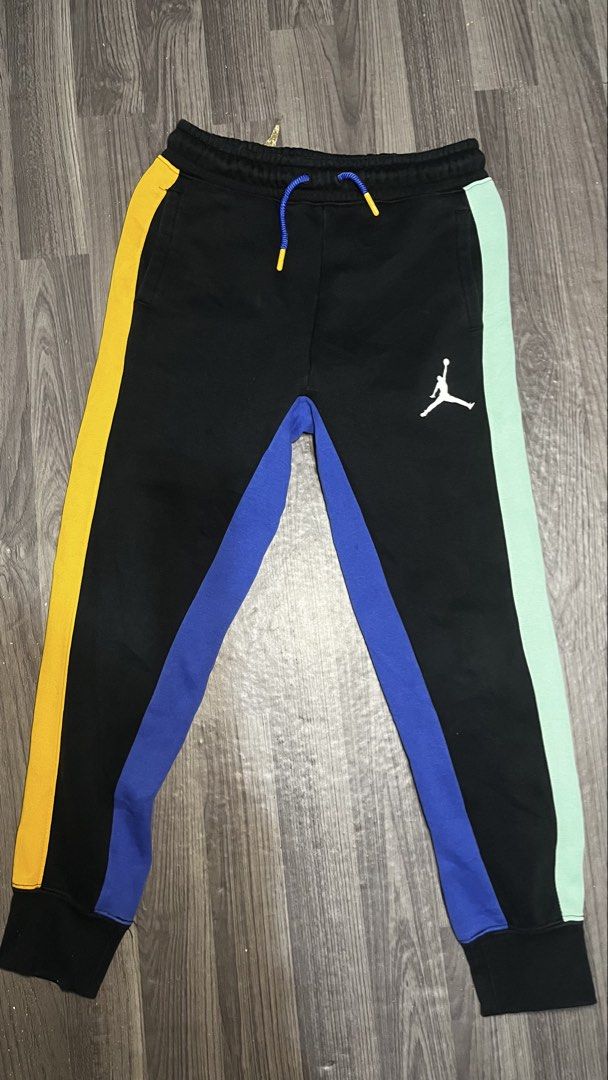 Jordan Multi-Color Panel Sweatpants Kids Size S (Category: Joggers) located in Caloocan City. Submitted by lucky_jhonel (Listing ID 1468658400, Image 2). Description: - Brand: Jordan - Color: Black with yellow, blue, and mint green side panels - Details: White Jumpman logo on left thigh, blue drawstrings with orange aglets - Fit: Elastic waistband and ribbed ankle cuffs - Material: 65% cotton, 35% polyester (machine washable).