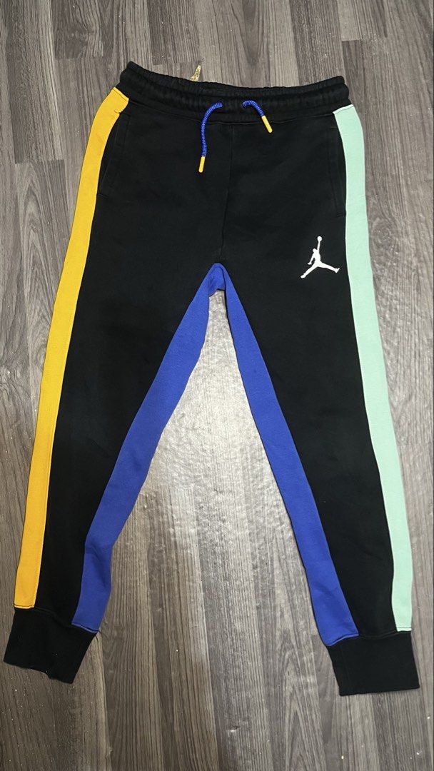 Jordan Multi-Color Panel Sweatpants Kids Size S (Category: Joggers) located in Caloocan City. Submitted by lucky_jhonel (Listing ID 1468658400, Image 1). Description: - Brand: Jordan - Color: Black with yellow, blue, and mint green side panels - Details: White Jumpman logo on left thigh, blue drawstrings with orange aglets - Fit: Elastic waistband and ribbed ankle cuffs - Material: 65% cotton, 35% polyester (machine washable).