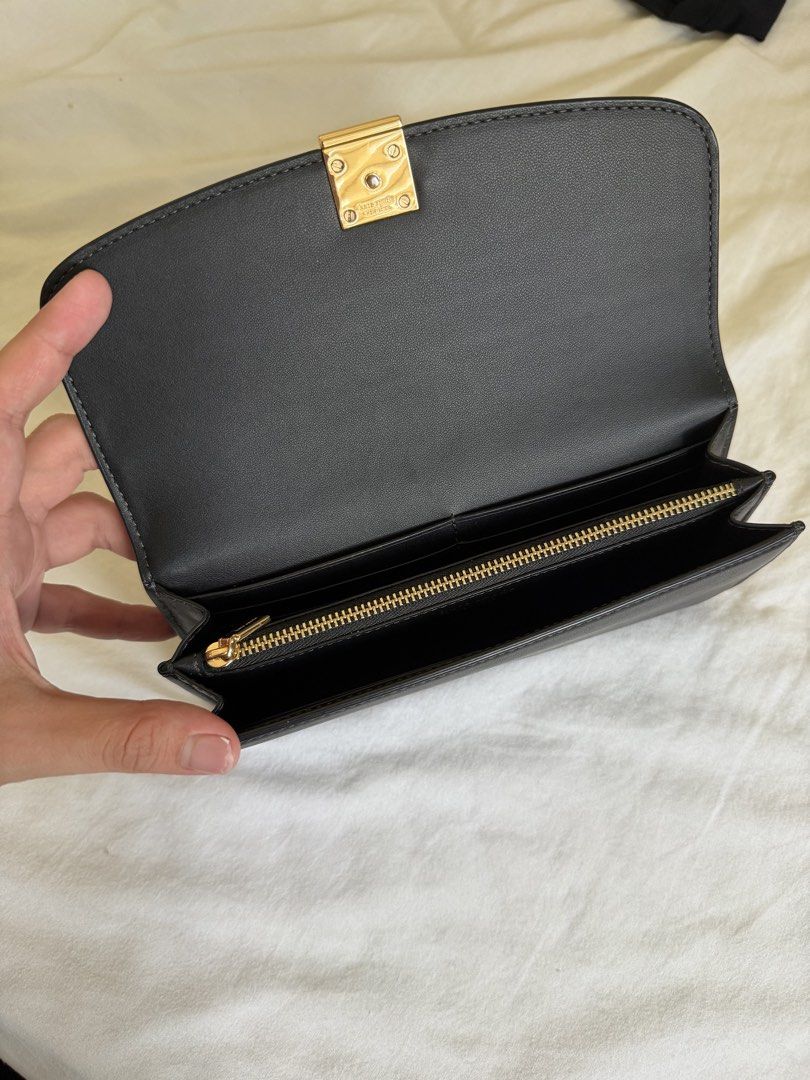 Kate Spade Black Leather Wallet with Gold Hardware (Category: Wallets & Card holders) located in Pasig City. Submitted by pipatyee (Listing ID 1468586591, Image 3). Description: - Authentic Kate Spade New York black leather wallet in standard continental size - Secure flap closure accented with a stylish modern geometric clasp - Elegant gold-tone hardware details throughout - Convenient exterior back slip pocket for quick card access - Well-organ