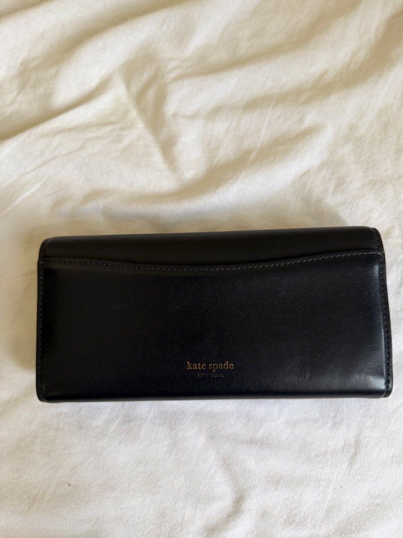 Kate Spade Black Leather Wallet with Gold Hardware (Category: Wallets & Card holders) located in Pasig City. Submitted by pipatyee (Listing ID 1468586591, Image 2). Description: - Authentic Kate Spade New York black leather wallet in standard continental size - Secure flap closure accented with a stylish modern geometric clasp - Elegant gold-tone hardware details throughout - Convenient exterior back slip pocket for quick card access - Well-organ