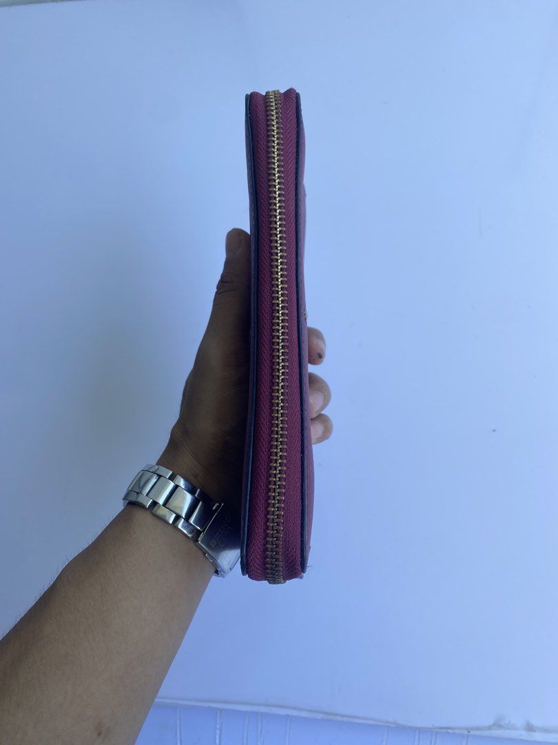 Kate Spade Burgundy Zip Around Wallet (Category: Wallets & Card holders) located in Cavite. Submitted by benta_bounce (Listing ID 1468555854, Image 3). Description: - Brand: Kate Spade - Style: Zip-around wallet - Material: Durable Saffiano leather - Color: Rich burgundy - Hardware: Gold-tone with matching leather zip pull - Exterior: Convenient back slip pocket - Branding: Signature spade logo stud on the front.