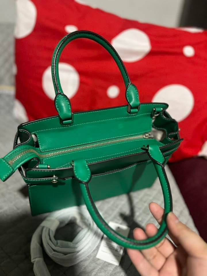 Kate Spade Green Satchel Bag (Category: Shoulder Bags) located in Polomolok. Submitted by legadad94559 (Listing ID 1468553944, Image 3). Description: - Brand: Kate Spade - Style: Medium satchel bag - Color: Vibrant green with gold-toned hardware - Material: Structured leather with fabric-lined interior - Closure: Secure top zip - Features: Dual top handles, interior slip pockets, and protective base feet - Inclusion: Wrapped detachable shoulder s