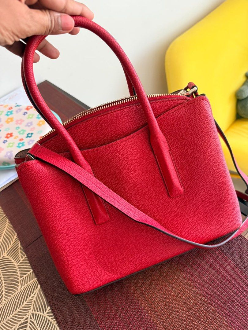 Kate Spade Medium Satchel Red Leather Bag (Category: Tote Bags) located in Quezon City. Submitted by safeflower.a95850 (Listing ID 1468516735, Image 2). Description: - Brand: Kate Spade - Color: Vibrant Red - Material: Genuine Leather - Hardware: Gold-tone - Closure: Zip top - Straps: Dual top handles & detachable shoulder strap - Interior: Signature fabric lining with zip and slip pockets - Extras: Original care card and store tags included - Co