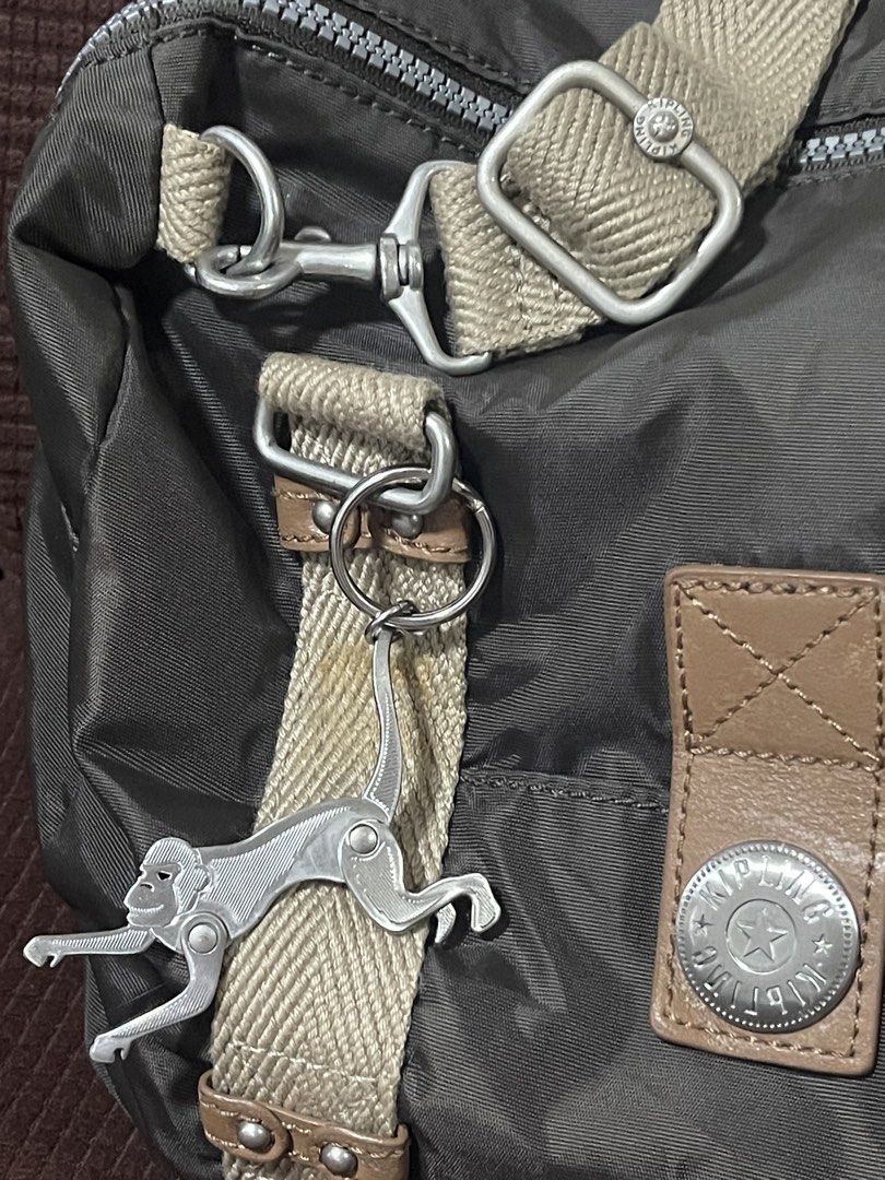Kipling Brown Nylon Shoulder Bag with Metal Monkey Keychain (Category: Shoulder Bags) located in Davao. Submitted by rcgulanes.moon (Listing ID 1468597761, Image 2). Description: - Brand: Kipling - Material: Durable brown nylon with leather trim - Color: Brown with neutral beige canvas straps - Hardware: Signature metal circular logo & iconic metal monkey keychain - Compartments: Exterior zippered pocket and interior striped fabric lining with a 