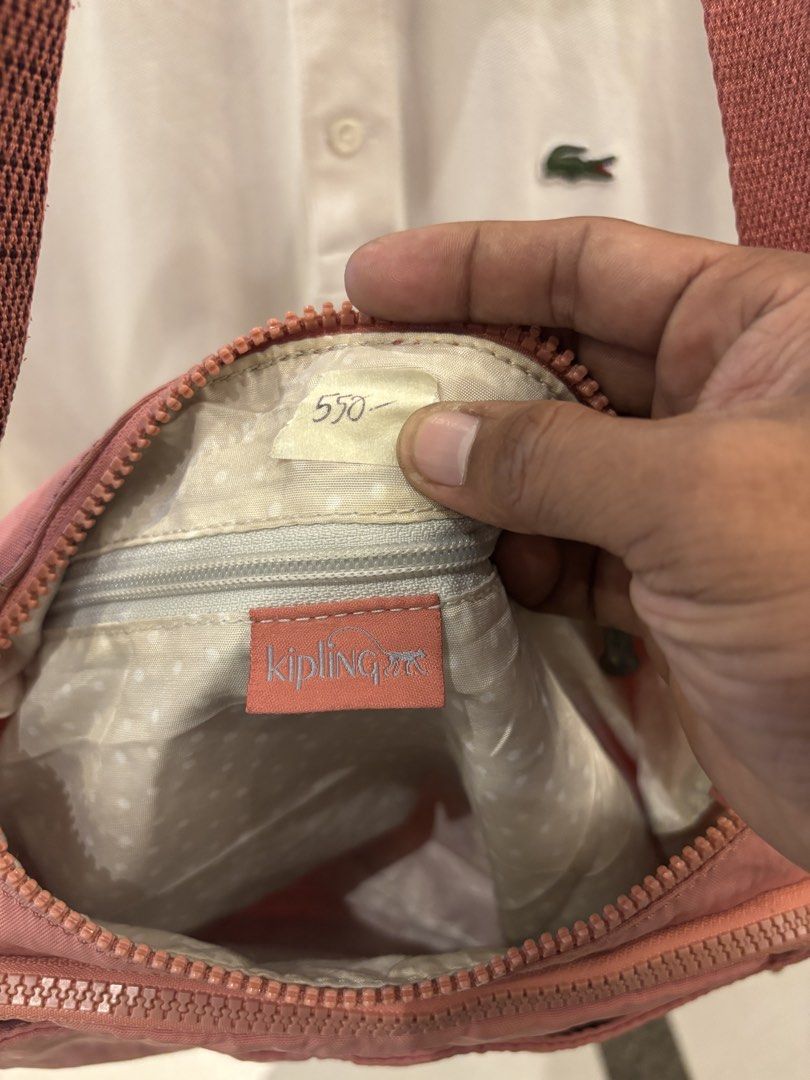 Kipling KI2587-47G Dusty Pink Shoulder Bag (Category: Shoulder Bags) located in Manila. Submitted by jeromskito66462 (Listing ID 1468676501, Image 3). Description: - Brand: Kipling - Model: KI2587-47G - Color: Dusty Pink - Material: Durable nylon (Made in Cambodia) - Exterior: Front zip pocket with round logo patch, adjustable strap - Interior: Cream polka dot lining, zip pocket, and brand logo tag - Condition: Clean inside and out, excellent rea