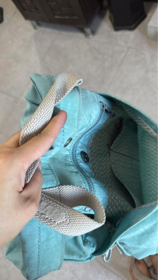 Kipling tote bag shoulder or backpack (Category: Tote Bags) located in Quezon City. Submitted by auspv_collections (Listing ID 1468619769, Image 2). Description: - Brand: Kipling - Color: Light Blue - Material: Signature crinkled nylon - Straps: Grey adjustable webbing straps - Pockets: Exterior front zip pocket and interior zippered pocket - Compartment: Spacious main compartment with patterned fabric lining - Details: Iconic circular Kipling lo
