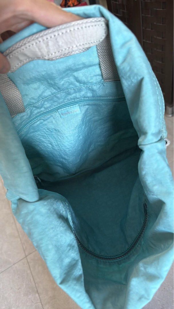 Kipling tote bag shoulder or backpack (Category: Tote Bags) located in Quezon City. Submitted by auspv_collections (Listing ID 1468619769, Image 3). Description: - Brand: Kipling - Color: Light Blue - Material: Signature crinkled nylon - Straps: Grey adjustable webbing straps - Pockets: Exterior front zip pocket and interior zippered pocket - Compartment: Spacious main compartment with patterned fabric lining - Details: Iconic circular Kipling lo
