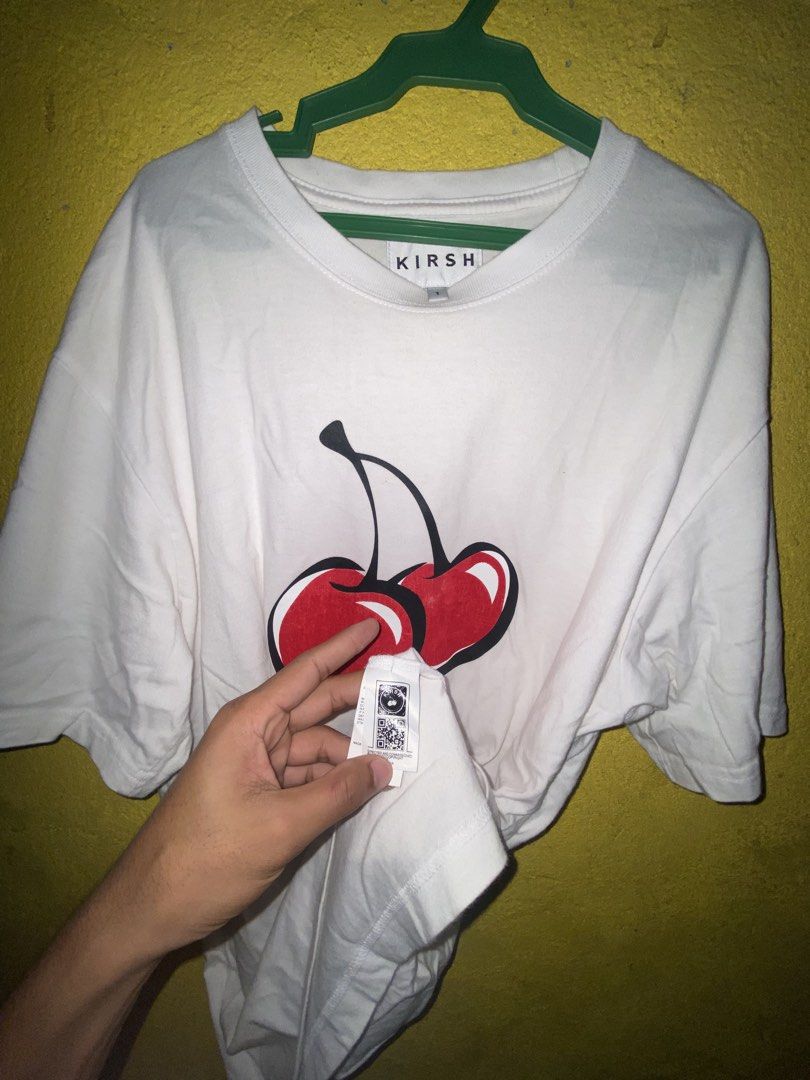 Kirsh Cherry White T-shirt Size 1 (Category: Shirts) located in Cagayan de Oro. Submitted by zekoy (Listing ID 1468626247, Image 2). Description: - Authentic Kirsh t-shirt in clean white - Features a large signature cherry graphic on the chest - Small embroidered cherry logo on the left sleeve - Crew neck and short sleeves - Size: 1 - Includes official authenticity tag near the hem.