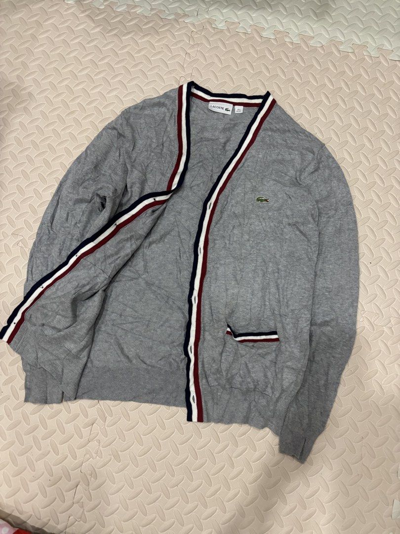 Lacoste Grey Striped V-Neck Cardigan (Category: Coats, Jackets and Outerwear) located in Manila. Submitted by noribrahim.20 (Listing ID 1468625146, Image 2). Description: - Brand: Lacoste - Style: V-neck button-up cardigan with stripe accents (navy, white, red along placket, collar, and pockets) - Material: 100% premium soft knit cotton - Color: Grey with dark buttons - Size: FR 6 / US XXL - Details: Iconic embroidered green crocodile logo on the