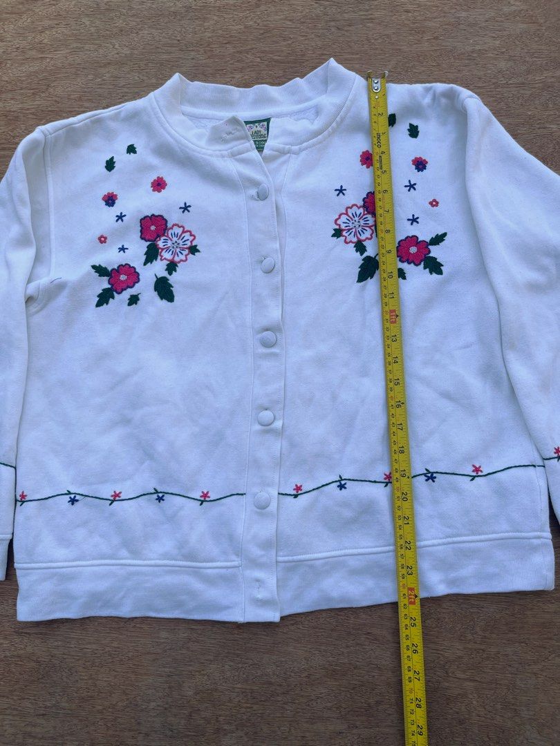 Lady Footlocker Cottage-core Cardigan (Category: Coats, Jackets and Outerwear) located in San Fernando. Submitted by p_thrifts (Listing ID 1468565907, Image 3). Description: - Brand: Lady Footlocker Casuals - Color: White with charming floral embroidery on chest, hem, and cuffs - Material: Soft and cozy cotton blend fleece - Style: Button-up front with a classic crew neck and long sleeves - Issue: Missing 2 buttons - Condition: Great pre-loved co