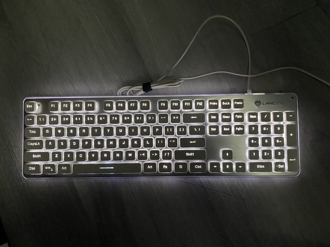 LANGTU L1 Wireless Silent Keyboard (Category: Computer Keyboard) located in Caloocan City. Submitted by anne_dcz (Listing ID 1468675719, Image 2). Description: Selling a LANGTU L1 wireless silent keyboard with white backlit keys, metallic silver panel, and full-sized layout. Perfect for both office and gaming setups. Plug-and-play ready!.