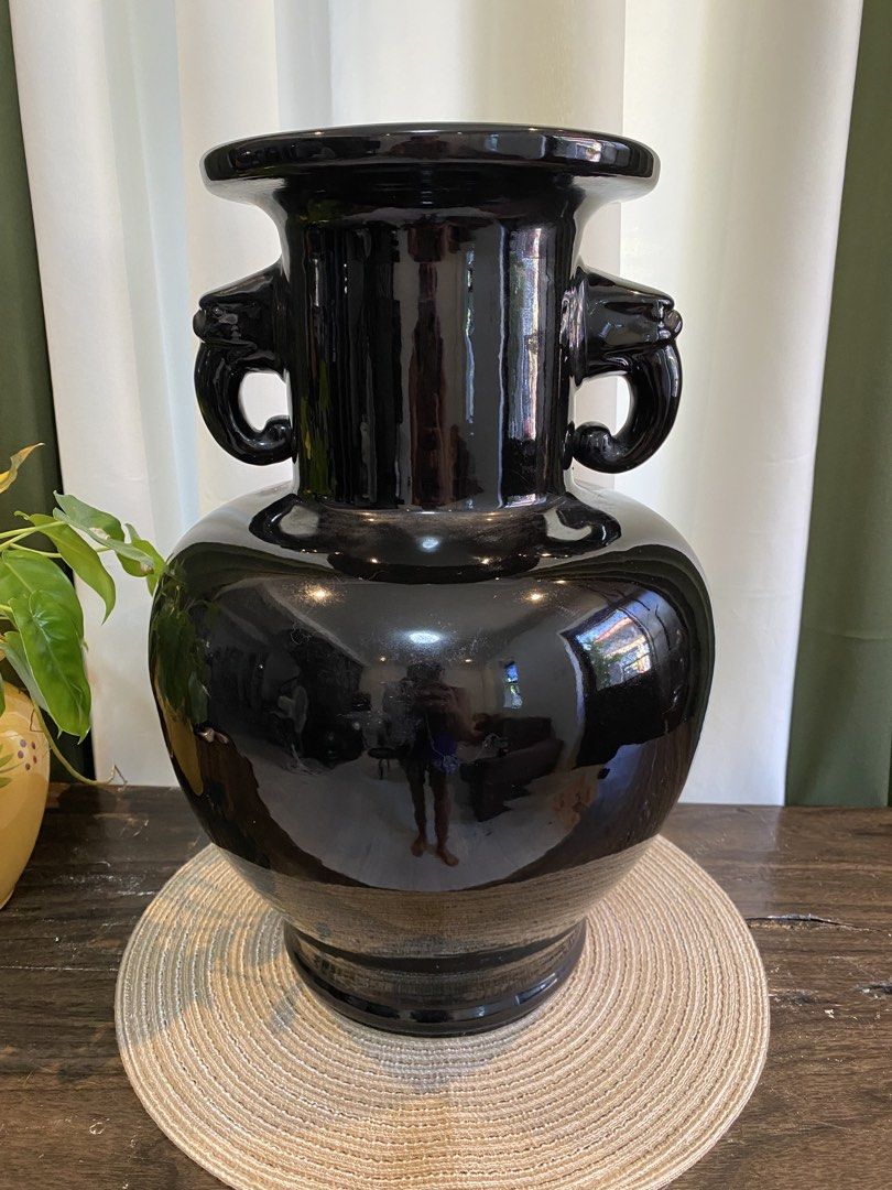 Large Black Ceramic Vase with Animal Head Handles (Category: Vases & Decorative Bowls) located in San Pedro. Submitted by jingay81 (Listing ID 1468708555, Image 1). Description: - Large black ceramic vase with a sleek high-gloss finish - Features detailed animal head handles on both sides - Elegant flared rim and wide bulbous body - Note: Has a noticeable repair patch near the base, as shown in the last photo - Makes a bold statement piece for an